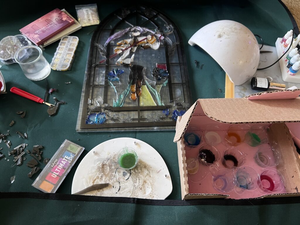 progress image of stained glass laser cut project shown among other tools and materials