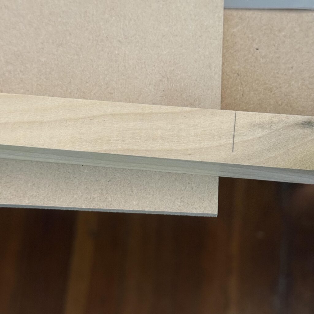 A close up of a mark on the square stock with a pencil mark showing where it needs to be cut to length.