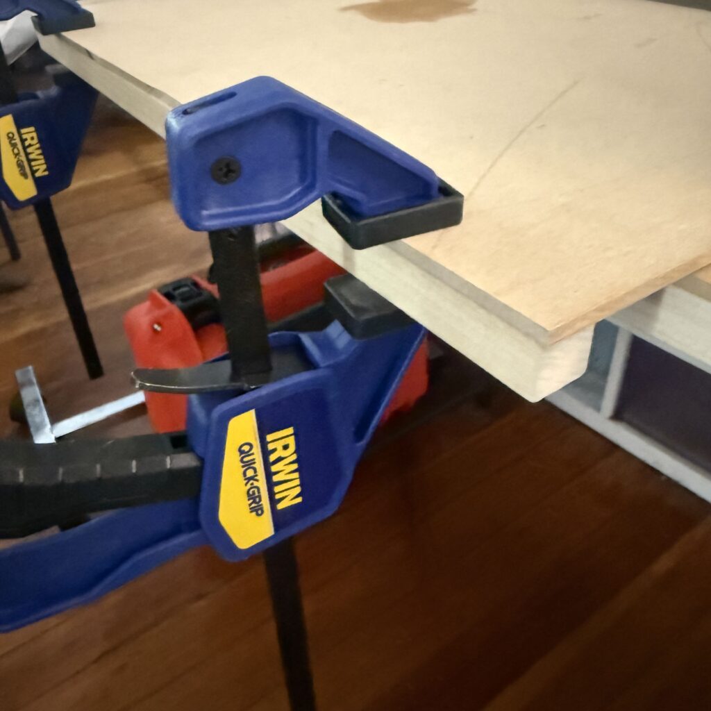 The square stock clamped to the edge of the MDF sheet.